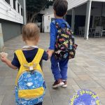 Two boys wearing backpacks.