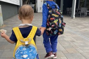 Two boys wearing backpacks.