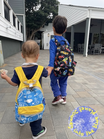 Two boys wearing backpacks.